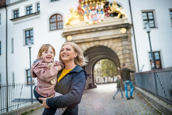 Eine Oma läuft mit ihrem Enkelkind auf der Schlossbrücke